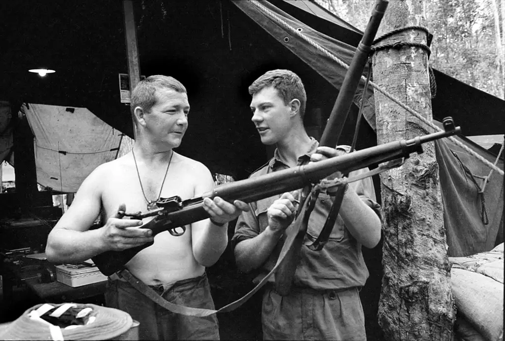 Sergeant Brian Walsh and 2nd Lieutenant Jim Fitzsimon, both of 7RAR, checking an American .30-06 calibre M1917 rifle and a 7.92-mm German Mauser Model 98