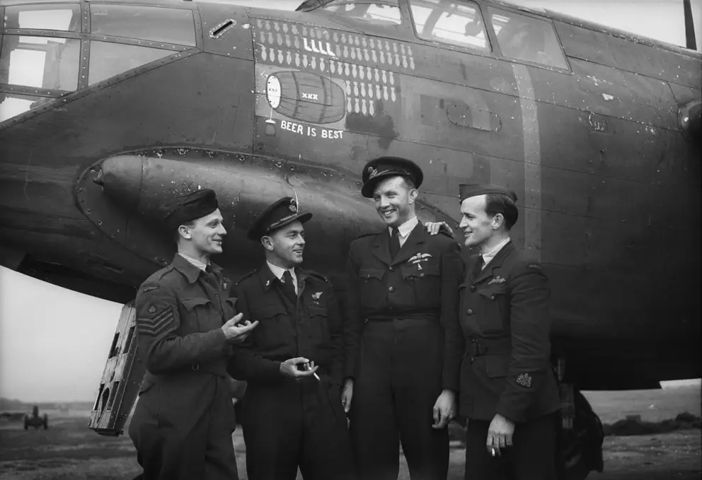 ENGLAND. 1944-07-31. AUSTRALIAN AIRCREW WHO FLY BOSTON AIRCRAFT OF NO. 88 SQUADRON RAF IN THE SECOND TACTICAL AIR FORCE IN FRONT OF THE AIRCRAFT EMBLEM "XXX BEER IS BEST". AWM UK1677