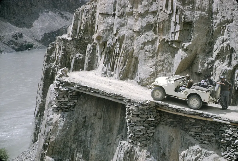 The road  between Skardu  (Pakistani territory) and  Kargil (Indian territory)  winding along the Indus  River, July 1965. The  road was built by hand  by Pakistani engineers.  Photo: Barrie Malcolm Newman. AWM P05689.044