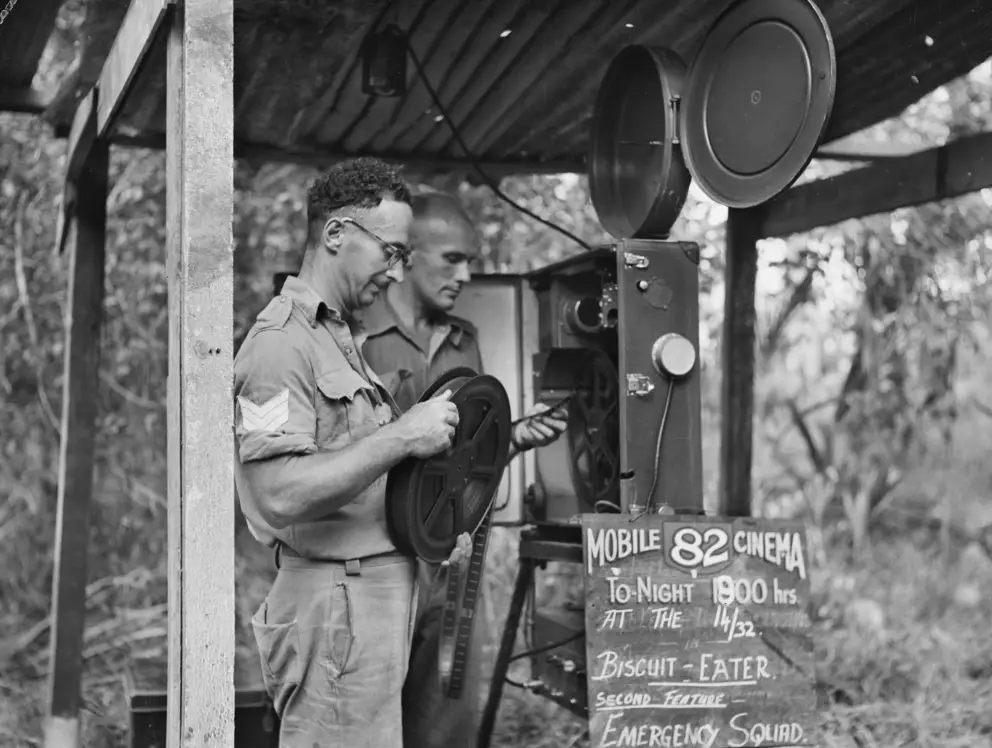 Members of Mobile Cinema Unit 82 prepare their projector before an evening show, New Britain, 1945.